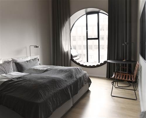 Where to stay in Copenhagen - Minimalist Hotel Room With Round Window